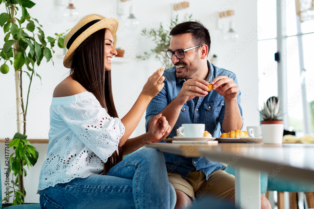 Happy couple talking at cafe, eating lunch. - Image