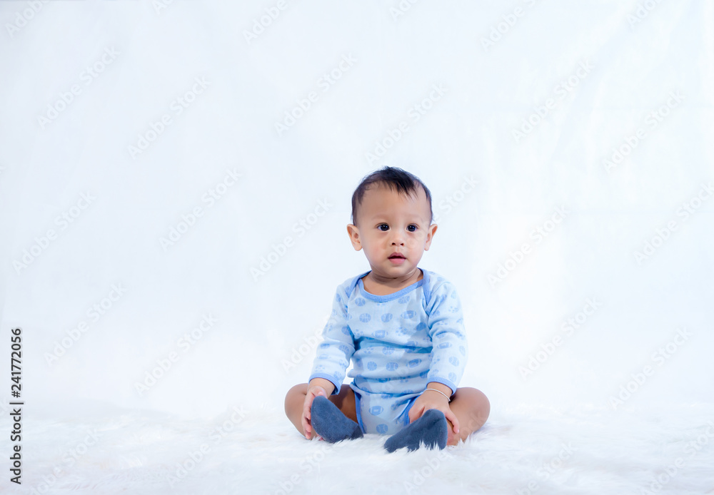 smile baby boy is shooting in the studio. fashion image of baby and family. Lovely baby sit down on a soft white carpet. image for background, wallpaper, copy space, objects, fashion and article smile baby boy is shooting in the studio. fashion image of baby and family. Lovely baby sit down on a soft white carpet. image for background, wallpaper, copy space, objects, fashion and article