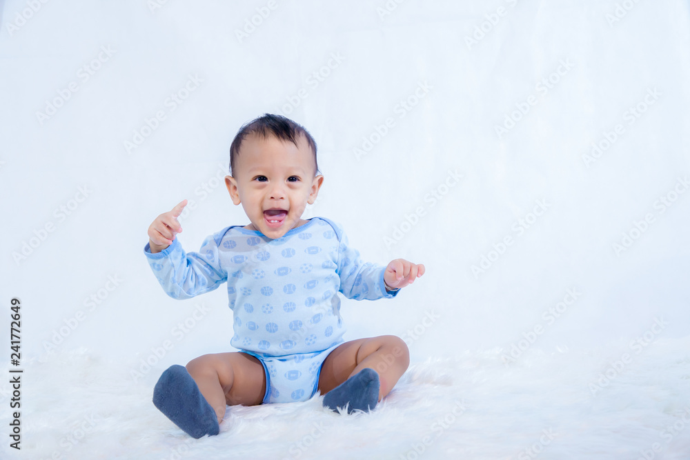 smile baby boy is shooting in the studio. fashion image of baby and family. Lovely baby sit down on a soft white carpet. image for background, wallpaper, copy space, objects, fashion and article smile baby boy is shooting in the studio. fashion image of baby and family. Lovely baby sit down on a soft white carpet. image for background, wallpaper, copy space, objects, fashion and article
