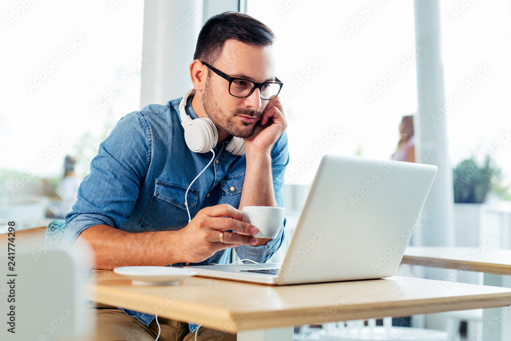 Happy man drinking coffee and looking at his laptop. - Image Happy man drinking coffee and looking at his laptop. - Image