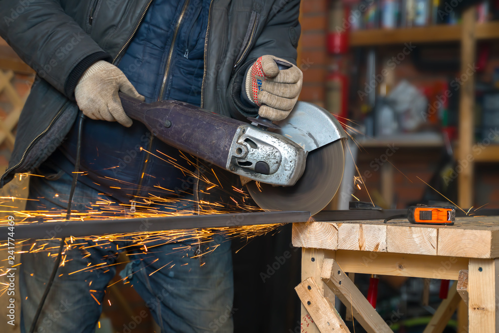 man cuts off metal pipe grinder in room. man cuts off metal pipe grinder in room.