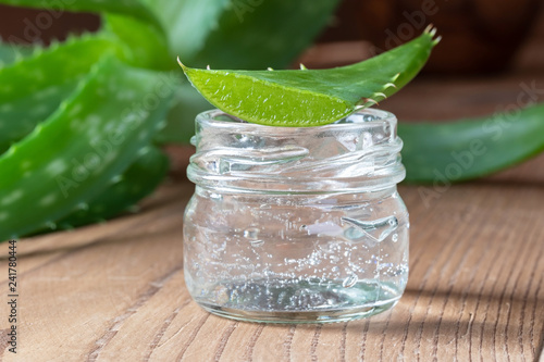 Aloe vera gel in a glass jar with fresh aloe vera leaf