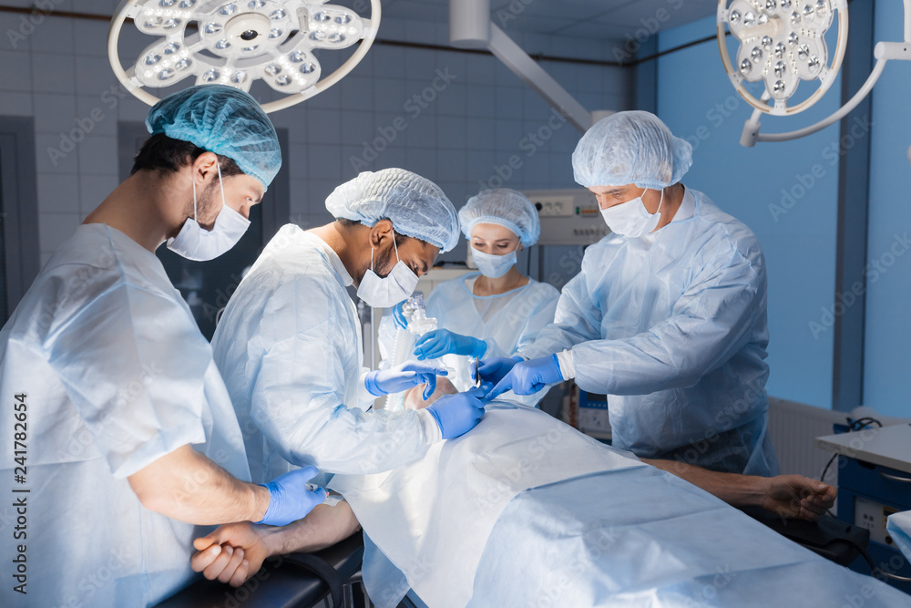 Urgent surgery. Professional smart intelligent surgeons standing near