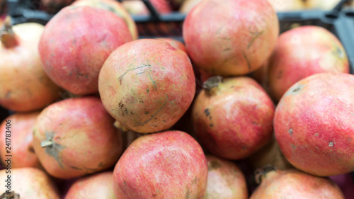 Closeup of red grapefruits in the market. Top view of ripe red organic pomegranates in market. Fresh pomegranates blurred image