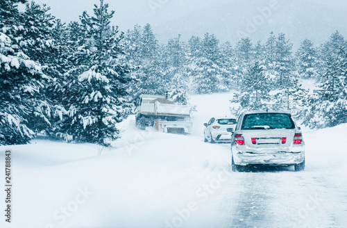 Traffic cars on winter road in snow blizzard