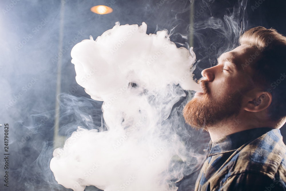 young ginger man is kvelling from the smoke. close up side view shot. cool  man taking pleasure in smoking Stock-Foto | Adobe Stock