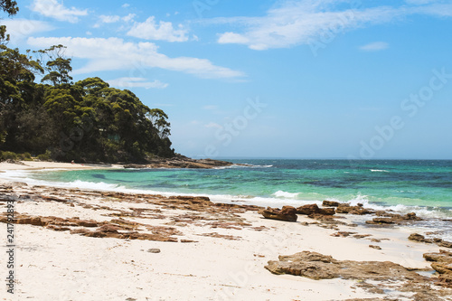 Rock formations in front of a forest at Hyams Beach - the world's whitest beach - at Jervis Bay on a beautiful summer day with azure water (Jervis Bay, Australia)