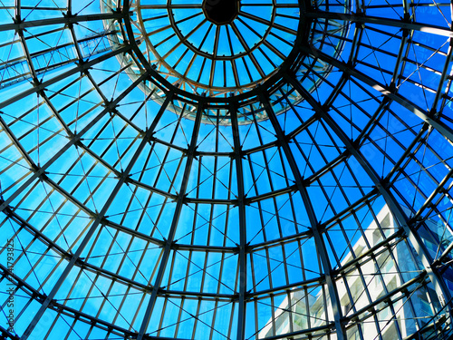 Silhouette half top circle ceiling dome roof white steel structure architecture shadow  distributed line surround  transparent clear glass wall with reflection  bright blue sky  building background