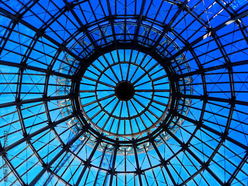 Silhouette top center circle ceiling dome roof white steel structure architecture, round dot shadow, distributed line surround, transparent clear glass wall with reflection, bright blue sky background