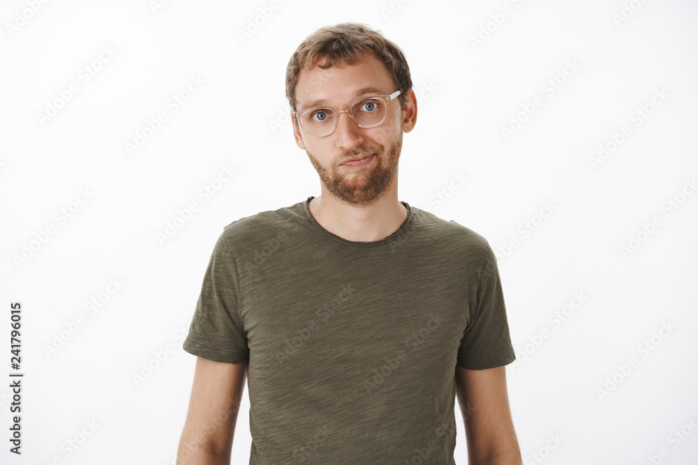 Portrait of cute and helpful good-looking male friend in glasses and green casual t-shirt smiling friendly at camera standing relaxed and calm over white background having normal conversation Portrait of cute and helpful good-looking male friend in glasses and green casual t-shirt smiling friendly at camera standing relaxed and calm over white background having normal conversation