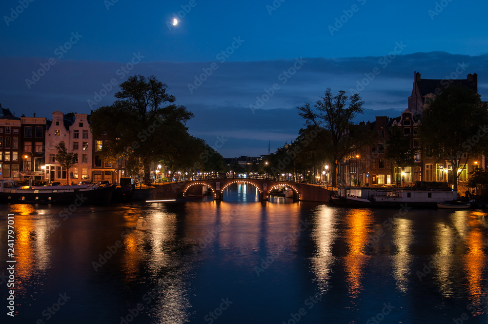 romantic evening view over a canal in amsterdam