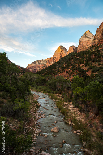 Rocks in the Virgin River, with towering cliffs above, Zion National Park, UT
