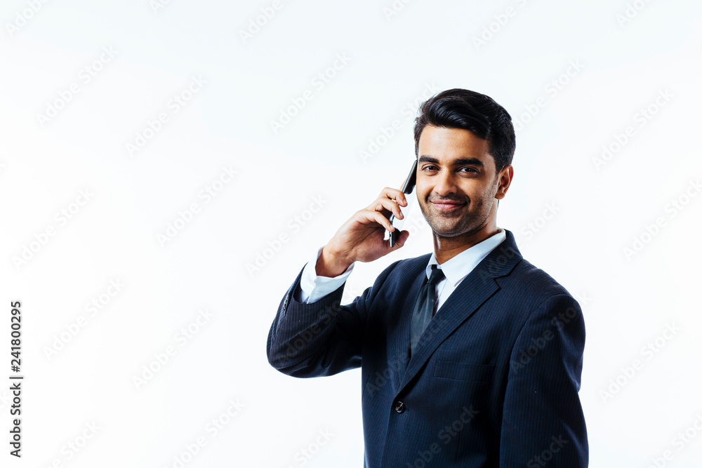 Portrait of a handsome businessman entrepreneur talking on the phone, smiling. looking at camera. white isolated background. Portrait of a handsome businessman entrepreneur talking on the phone, smiling. looking at camera. white isolated background.