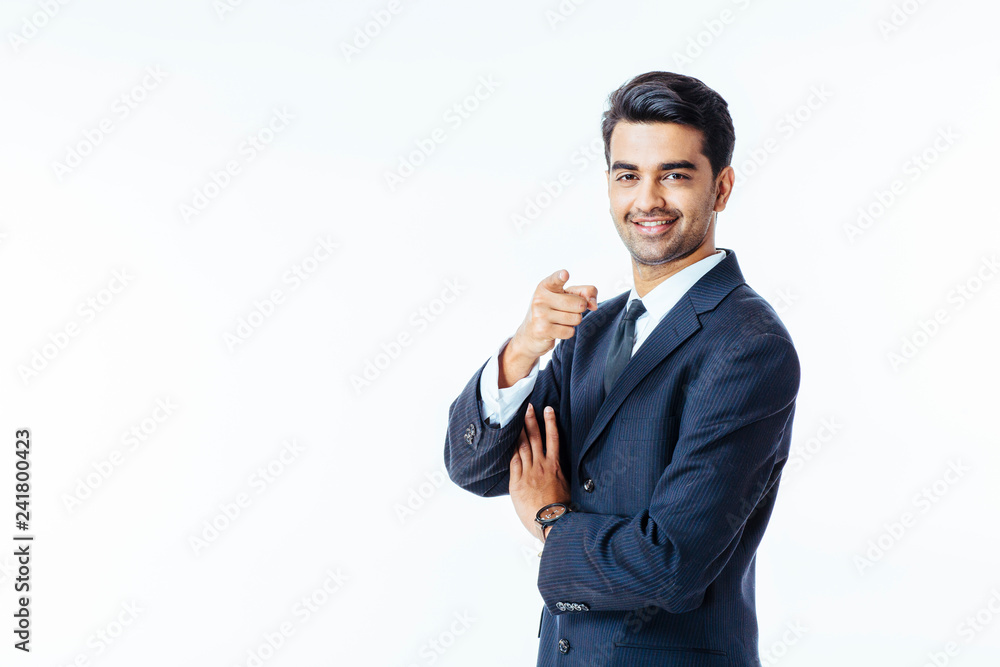 Portrait of a smiling businessman in black suit and tie pointing at camera isolated on white background Portrait of a smiling businessman in black suit and tie pointing at camera isolated on white background