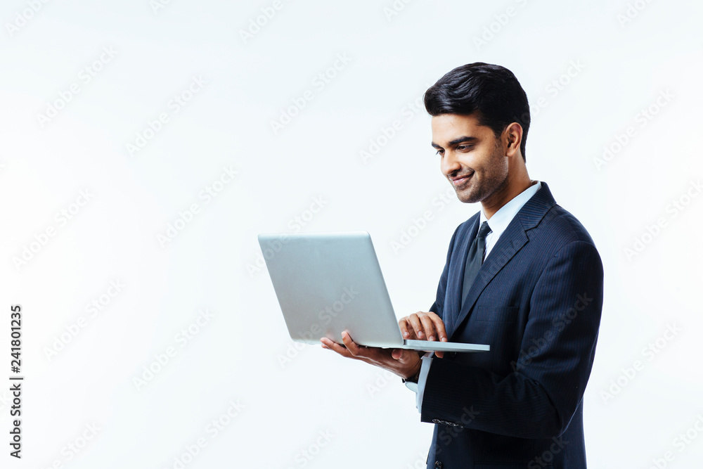 Portrait of a confident young man entrepreneur in business suit working on a laptop, isolated on white background Portrait of a confident young man entrepreneur in business suit working on a laptop, isolated on white background