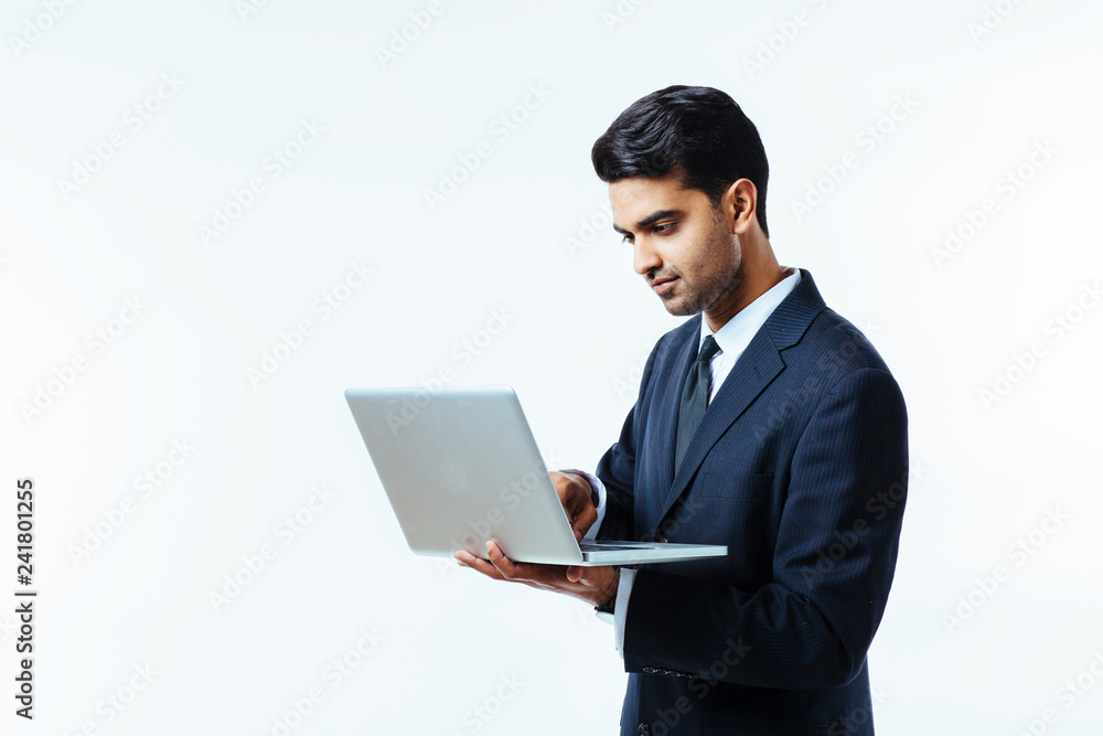 Portrait of a confident young man entrepreneur in business suit working on a laptop, isolated on white background Portrait of a confident young man entrepreneur in business suit working on a laptop, isolated on white background