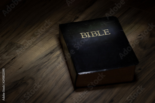 Dramatic lighting on Holy Bible, text space on side of bible great use a background.