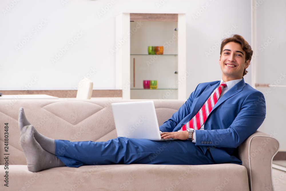 Young businessman working at home sitting on the sofa Young businessman working at home sitting on the sofa
