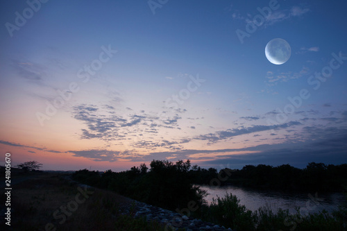 朝焼けが川面を染める朝の月 © Seiichi Fukui