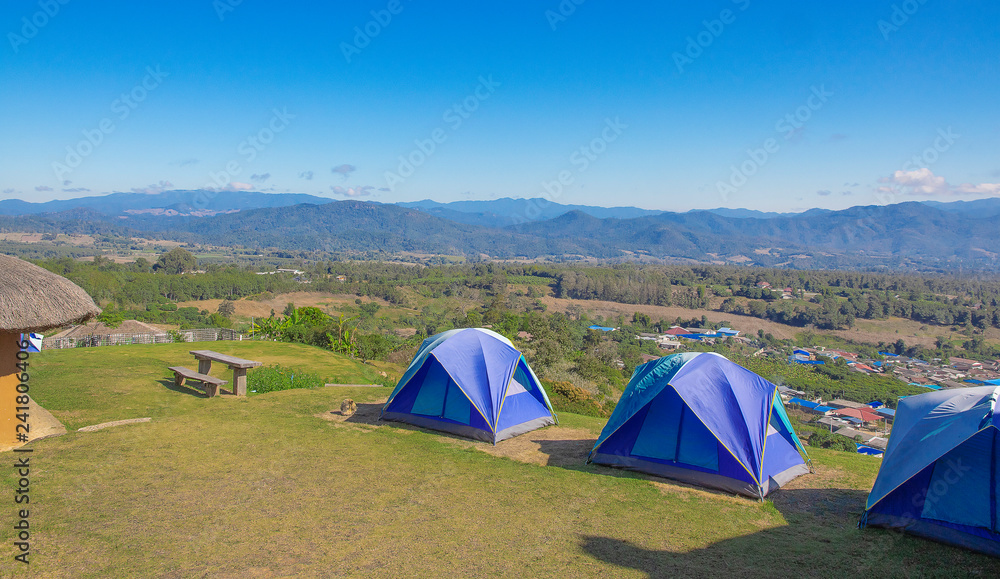 Three tents of blue on the high hills. Background blue sky and  mountain.