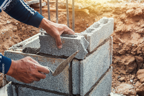 Fotobehang worker installing bricks in construction site
