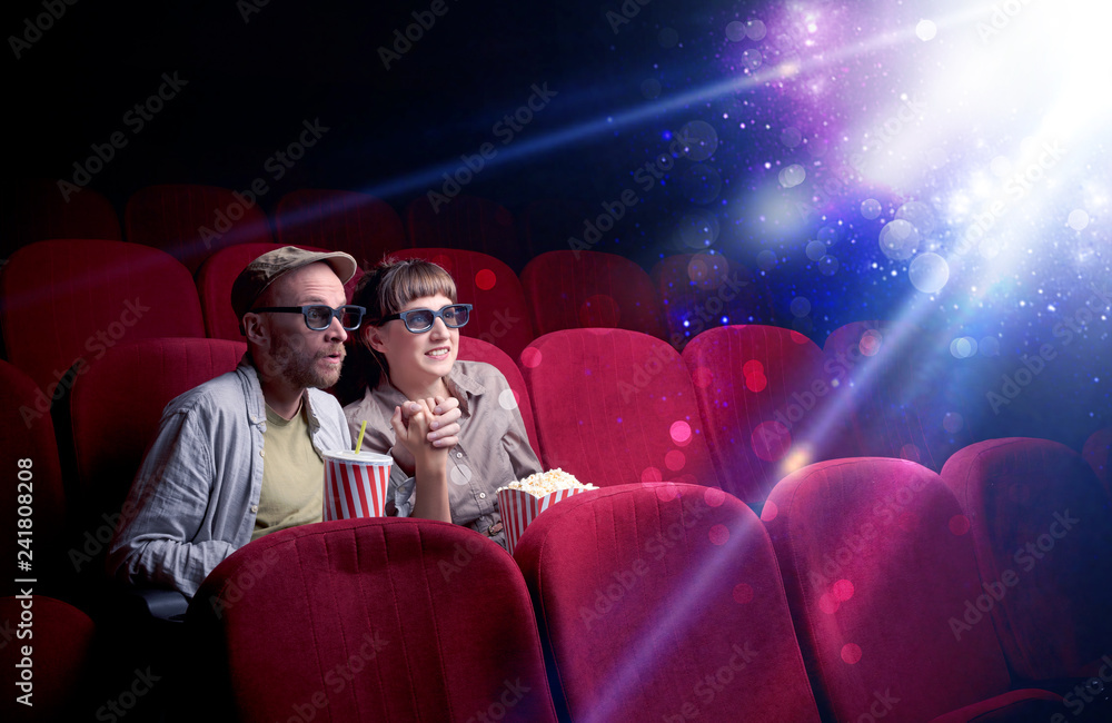Obraz premium Romantic couple cuddling and watching the miraculous part of the film