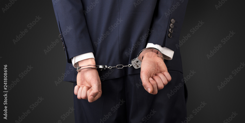 Close now arrested men hand with dark background and handcuffs
