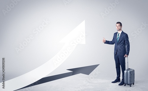 Young businessman hitchhiking with progressive arrow concept and copyspace
 photo