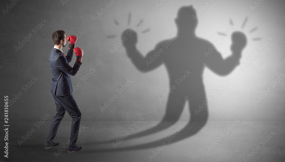 Businessman trying to fight with his unarmed shadow
Businessman trying to fight with his unarmed shadow