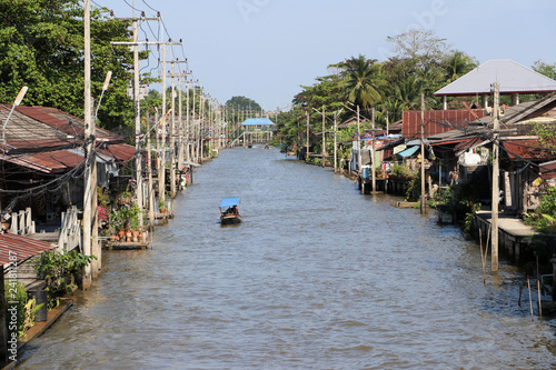 Life along the canal and long tail boat driving the on the Damnoensaduak canal. photo