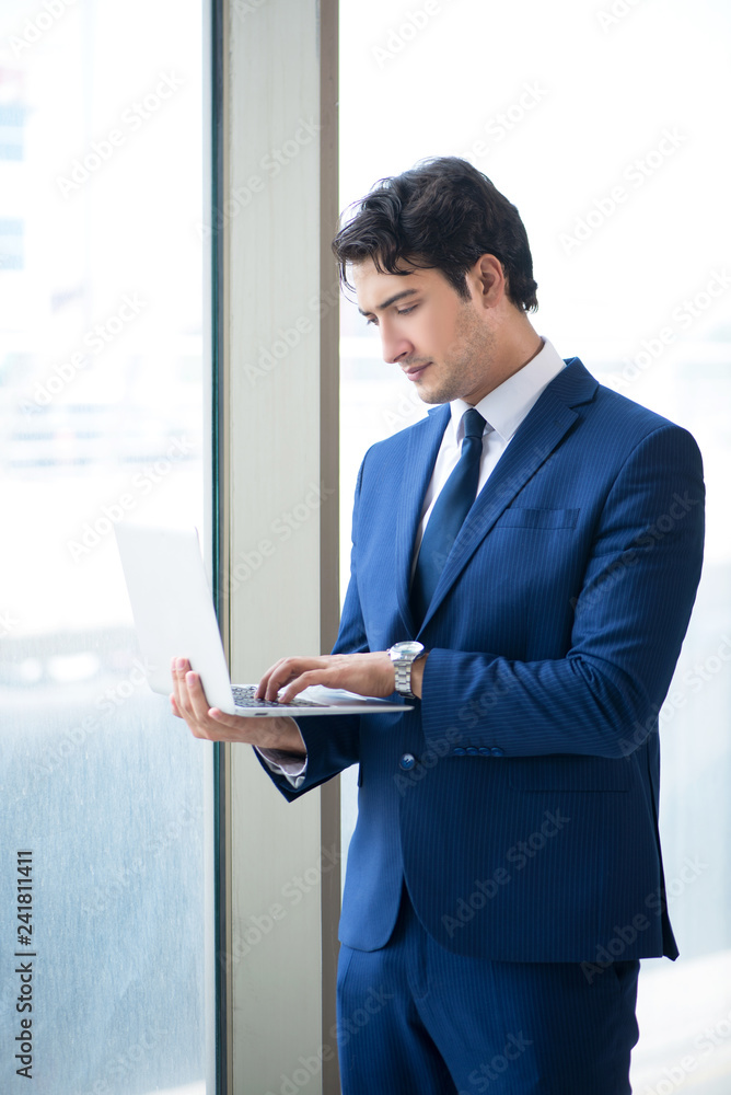 Young handsome businessman standing at the window Young handsome businessman standing at the window