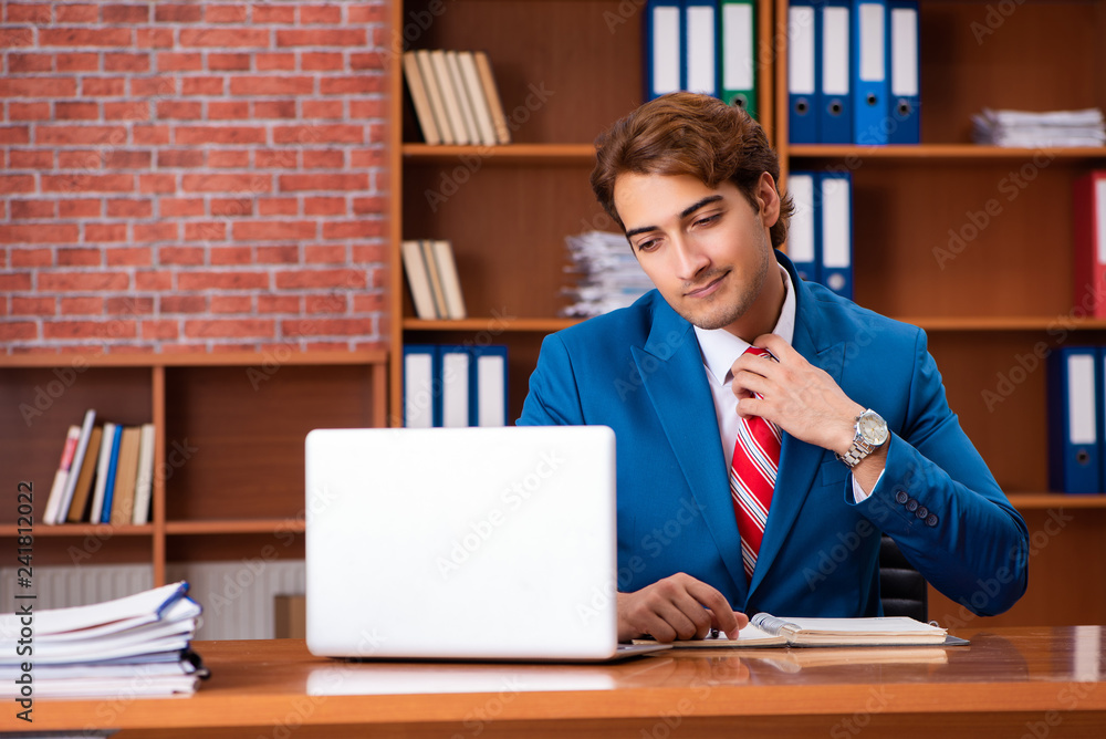 Young handsome employee sitting in the office Young handsome employee sitting in the office
