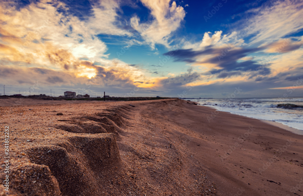 Sandy empty sea beach at sunset time Sandy empty sea beach at sunset time