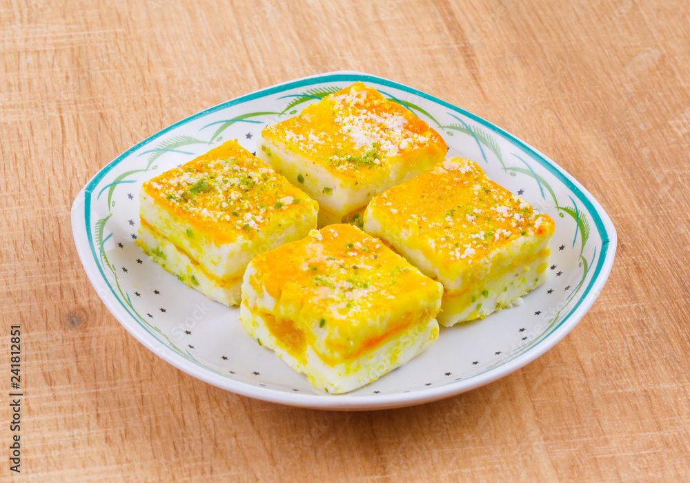 Paneer Burfi or Paneer Kesar Burfi is a Traditional Indian Mithai or Sweet Dish Prepared From Freshly Made Paneer, Mawa, Milk or Cottage Cheese on Wooden Background Paneer Burfi or Paneer Kesar Burfi is a Traditional Indian Mithai or Sweet Dish Prepared From Freshly Made Paneer, Mawa, Milk or Cottage Cheese on Wooden Background