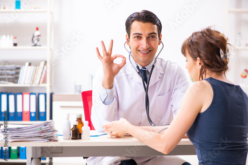 Young doctor checking woman s blood pressure