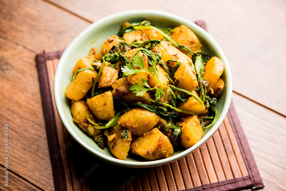 Aloo Palak sabzi - Potato cooked with spinach with added spices. a healthy Indian main course recipe. Served in a bowl, selective focus Aloo Palak sabzi - Potato cooked with spinach with added spices. a healthy Indian main course recipe. Served in a bowl, selective focus