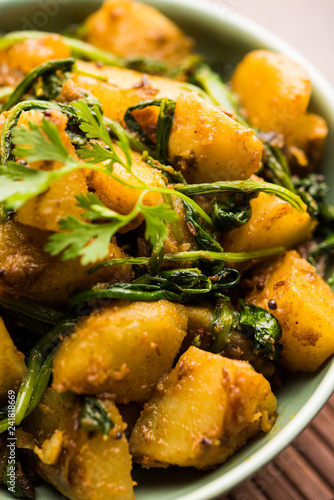 Aloo Palak sabzi - Potato cooked with spinach with added spices. a healthy Indian main course recipe. Served in a bowl, selective focus photo