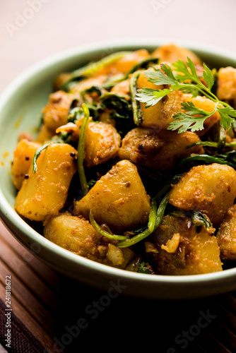 Aloo Palak sabzi - Potato cooked with spinach with added spices. a healthy Indian main course recipe. Served in a bowl, selective focus photo