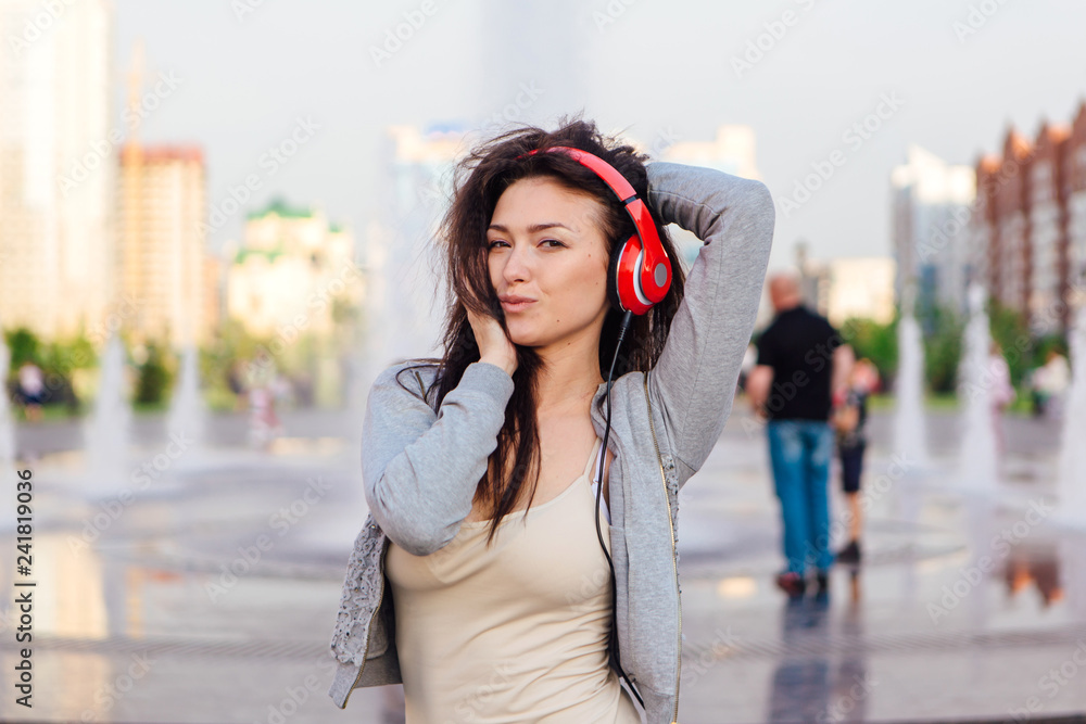 Girl listening to music streaming with headphones and making funny face.