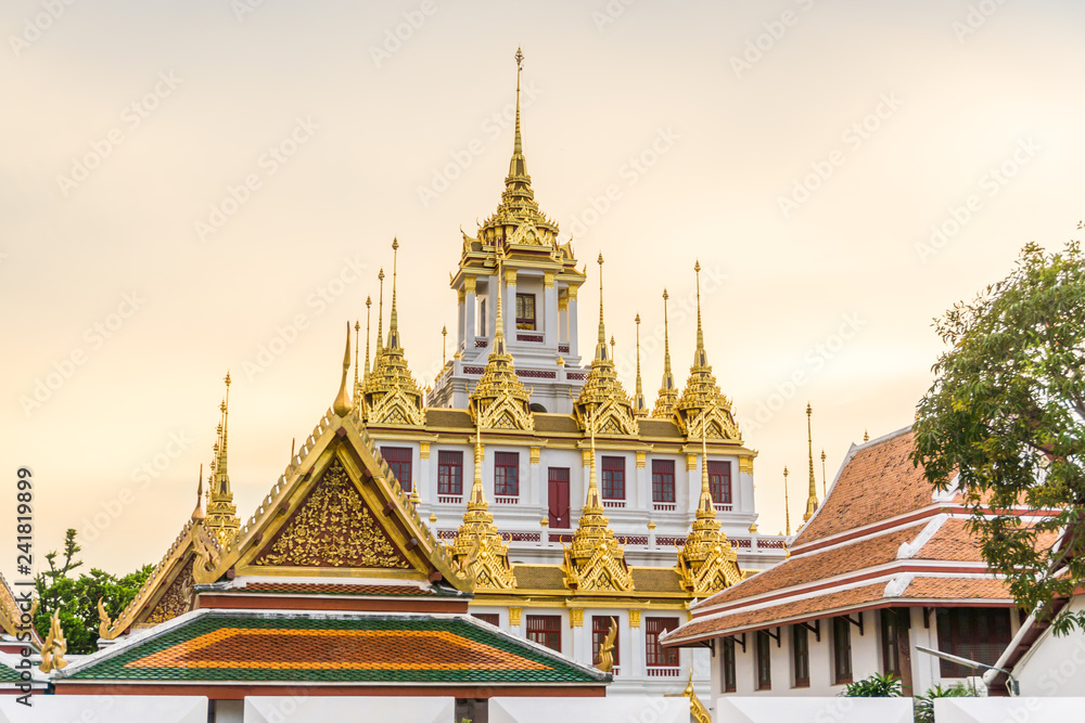 Naklejka premium Loha Prasart metal buddhist temple golden pagoda sunset sky with cloud