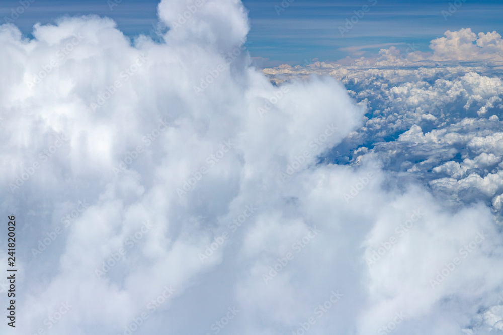 Beautiful view from window of plane flying over clouds. Natural panorama with clouds. White clouds moving above the ground. Beautiful view from window of plane flying over clouds. Natural panorama with clouds. White clouds moving above the ground.