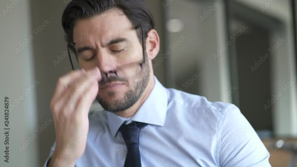 Attractive businessman looking worried and tired infront of laptop Attractive businessman looking worried and tired infront of laptop