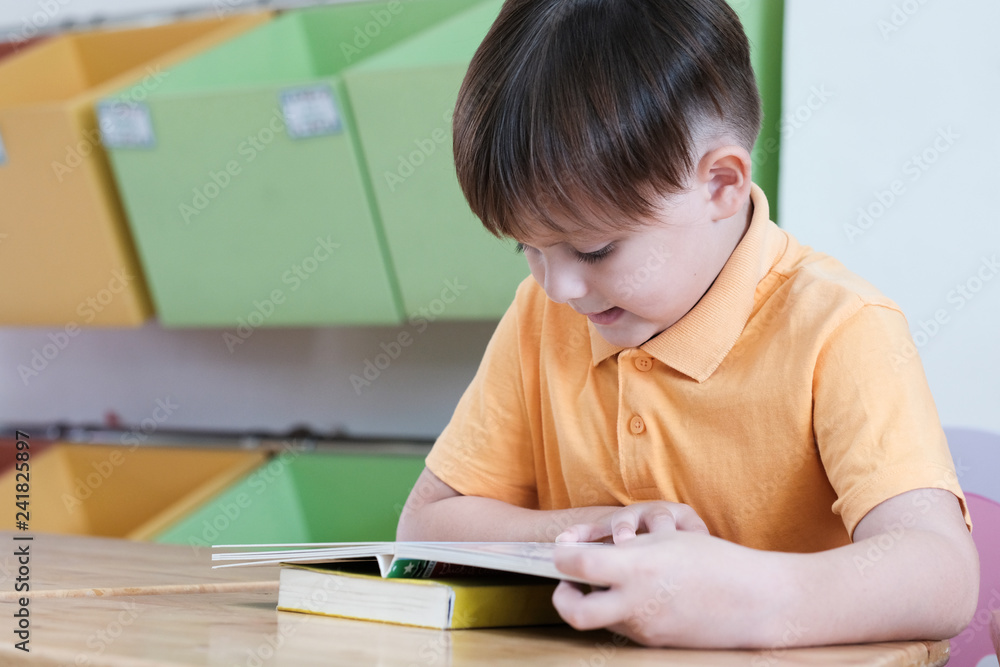 Boys reading book in their kindergarten classroom, kid education concept Boys reading book in their kindergarten classroom, kid education concept