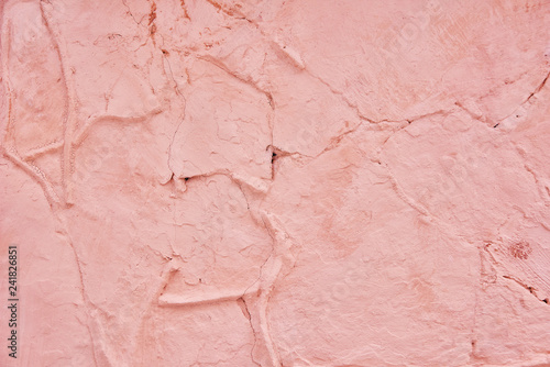 Textured background pink cracked plaster partially sprinkled with a dark rose shaded cracked wall. Grunge background