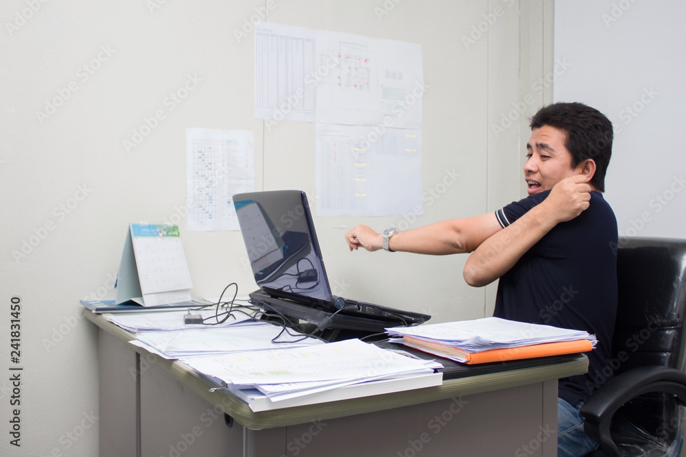 A man working in the office him serious and headache with burnout A man working in the office him serious and headache with burnout