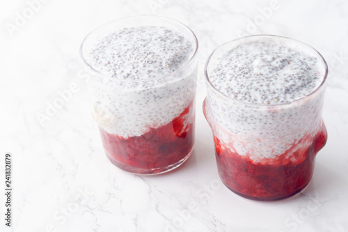 Two glasses of chia pudding with strawberry smoothie