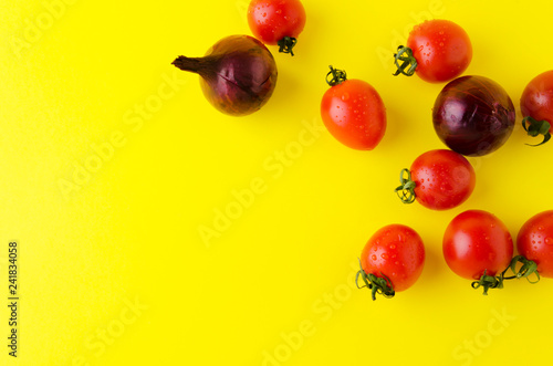 Top view of vegetables on bright yellow background.Onions,fresh tomatoes on modern background
