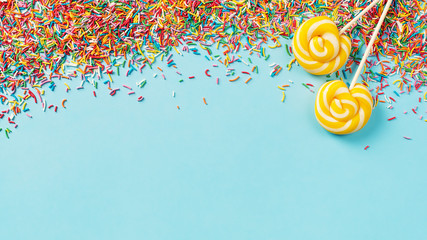 Birthday and party concept background with confetti and lollipop on blue