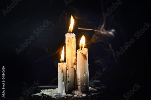 Group of white candles burning in the dark