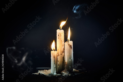 Group of white candles burning in the dark